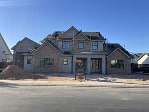 View of front facade featuring stucco siding and brick siding