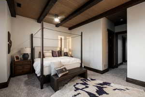 Carpeted bedroom featuring a wood ceiling with exposed beams