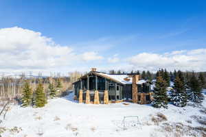 Snow covered house featuring a chimney