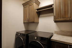 Washroom with cabinet space and washing machine and clothes dryer