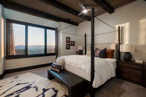 Carpeted bedroom featuring a wooden ceiling with exposed beams