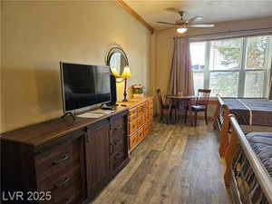 Bedroom with light wood-type flooring and crown molding