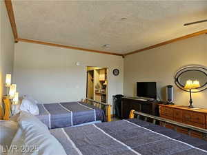 Bedroom featuring ornamental molding and a textured ceiling