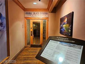 Hallway featuring ornamental molding and dark wood-style floors