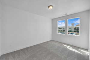 Spare room featuring carpet flooring and baseboards