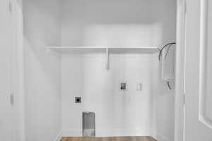 Washroom with hookup for a washing machine, hookup for an electric dryer, and wood finished floors