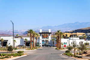 View of asphalt street with traffic signs, a mountain view, street lights, curbs, and a residential view