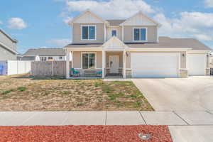 View of front of home featuring board and batten siding, a porch, driveway, and stone siding