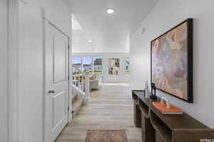 Corridor featuring light wood finished floors, stairs, and recessed lighting