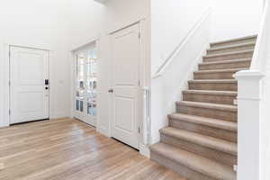 Foyer featuring wood finished floors, stairs, and french doors