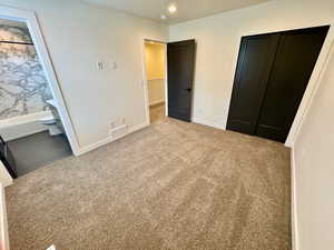 Unfurnished bedroom featuring carpet, a closet, and ensuite bathroom