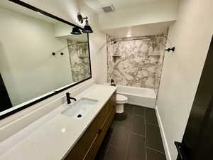 Bathroom with vanity, shower / tub combination, and tile patterned floors