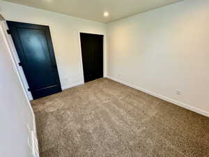 Unfurnished bedroom with carpet flooring and recessed lighting
