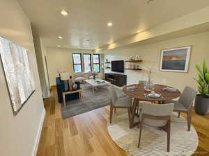 Dining room with light wood-type flooring and recessed lighting