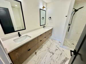Bathroom featuring a shower stall, double vanity, marble finish floors, and recessed lighting