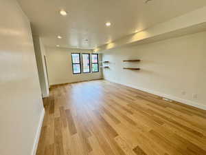 Empty room featuring light wood-type flooring and recessed lighting
