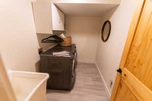 Laundry room with washer and clothes dryer and baseboards