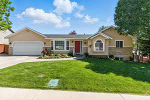Rambler home featuring stucco siding, driveway, and an attached garage