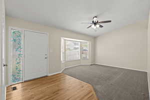 Foyer featuring ceiling fan and wood finished floors and carpet