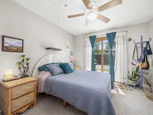 Carpeted bedroom featuring access to outside and ceiling fan