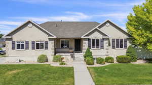 Ranch-style home with covered porch, a front yard, and stucco siding