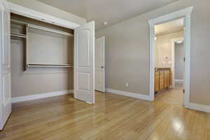 Unfurnished bedroom with light wood-style floors and a closet