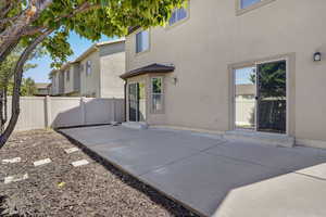 Rear view of property with stucco siding, a patio, and a fenced backyard