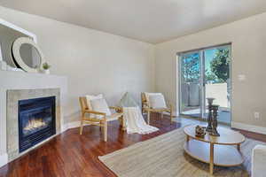 Sitting room with wood finished floors and a fireplace