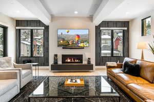 Living area featuring a glass covered fireplace, wood finished floors, recessed lighting, and healthy amount of natural light