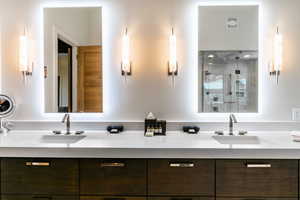 Bathroom featuring double vanity and a stall shower