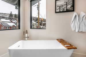 Full bath with a freestanding bath and baseboards