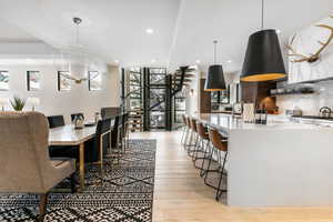 Dining space with stairs, healthy amount of natural light, light wood-style floors, recessed lighting, and a chandelier