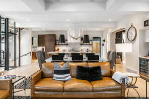 Living room with light wood finished floors, wine cooler, recessed lighting, and a chandelier