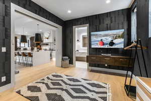 Living area with light wood-style flooring and recessed lighting