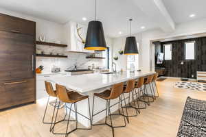 Kitchen with open shelves, light wood-style flooring, light countertops, tasteful backsplash, and recessed lighting