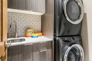 Washroom featuring stacked washer and clothes dryer