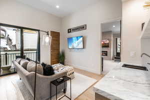 Living room featuring light wood-style flooring, a large fireplace, and recessed lighting
