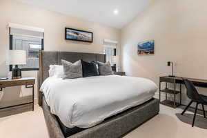 Carpeted bedroom with lofted ceiling and recessed lighting