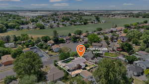 Aerial perspective of suburban area featuring property boundaries highlighted and a mountainous background