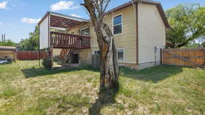 Rear view of property featuring stairs, a fenced backyard, and a deck