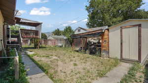 View of yard with a storage shed, a wooden deck, and stairway