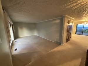 Unfurnished room featuring a chandelier, a textured ceiling, and crown molding