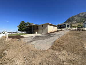 Rear view of house featuring a mountain view, asphalt driveway, and a garage