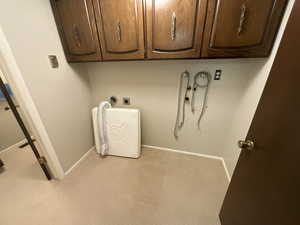Laundry room featuring hookup for an electric dryer, carpet, and cabinet space