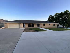 Ranch-style home with driveway, brick siding, a front lawn, and a garage