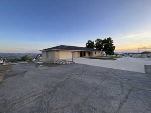 View of front of property with an attached garage, asphalt driveway, and brick siding