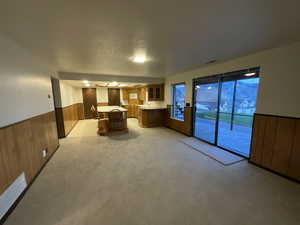 Kitchen featuring brown cabinets, wainscoting, light countertops