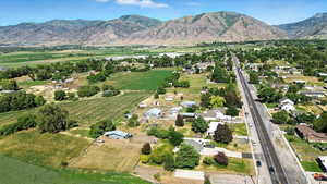 Aerial view of property and surrounding area featuring farmland, mountains, and rural landscape