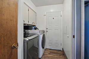 Laundry area with cabinet space, washer and dryer, and dark wood-type flooring