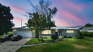Ranch-style house with brick siding, an attached garage, concrete driveway, and a front lawn